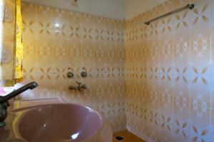 uma casa de banho com um lavatório e paredes em azulejo em Saffron Homestay em Jaisalmer