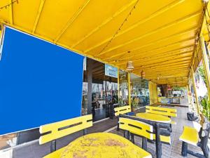 UMMUL MOTEL في أروا: مطعم بطاولات صفراء وكراسي على الفناء