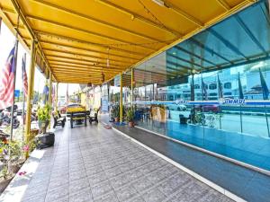 a building with a yellow ceiling and a walkway at UMMUL MOTEL in Arau