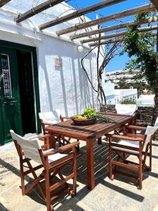 una mesa de madera y sillas en un patio en Fyrou- Serenity / Idyllic Traditional Experience, en Artemonas