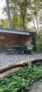 een houten hut met een picknicktafel en een bank bij 1850s Character Stone Cottage in Mold