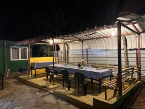 two tables and chairs under a greenhouse at night at The Wild Farms By Gwestai in Masinagudi