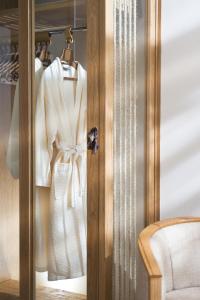 a closet with a white robe and a chair at Azia Resort & Spa in Paphos City