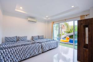 sypialnia z łóżkiem i przesuwnymi szklanymi drzwiami w obiekcie Space X Slider 4 Bedrooms Pool Villa Huahin w mieście Hua Hin