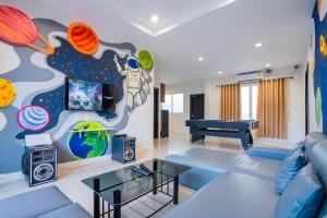 a living room with a blue couch and a mural at Space X Slider 4 Bedrooms Pool Villa Huahin in Hua Hin