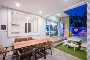 a dining room with a table and chairs and a window at Space X Slider 4 Bedrooms Pool Villa Huahin in Hua Hin