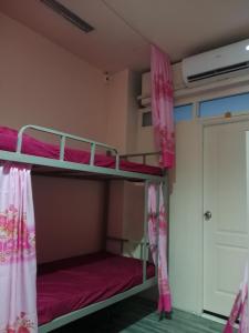 um beliche num quarto com cortinas cor-de-rosa em 1919house em Praia de Patong