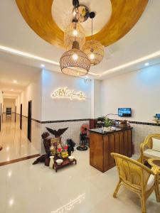 sala de estar con 2 lámparas de araña y mesa en A.N Homestay en Phan Thiet