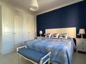 een slaapkamer met een bed met een blauwe muur bij Casa Morandi SPIAGGIA in San Vincenzo