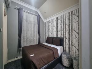 1 dormitorio con 1 cama y pared con un mural de árboles en Villa Kota Bunga EE3-15 en Cikundul