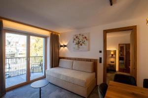 a living room with a couch and a balcony at Alpenresidenz Trisanna in Ischgl