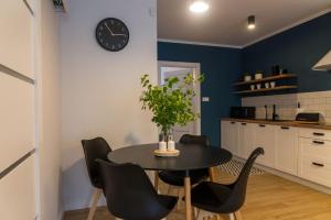 uma sala de jantar com mesa e cadeiras e um relógio em VacationClub – Spokojna 24E Apartament C.1 em Wisla