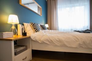 een slaapkamer met een bed, een bureau en een raam bij VacationClub – Spokojna 24E Apartament C.1 in Wisła