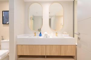 La salle de bains est pourvue de 2 lavabos et de 2 miroirs. dans l'établissement Burj Khalifa Views / 5 min walk from Dubai Mall / Dubai Opera / Upgraded / Designer Choice / 8 people / The Best Location, à Dubaï