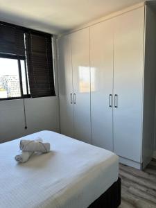 una camera da letto con un letto e un asciugamano sopra di Sweet Cozy CBD apartment a Windhoek