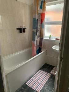 a bathroom with a bath tub and a sink at Cosy Apartment in London in London