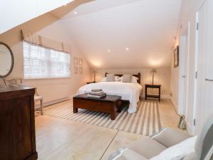 a large bedroom with a bed and a table at Lampland House in Southwold