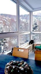 a bedroom with a view of a snow covered mountain at Apartament 46 Niedźwiedzie Zacisze blisko Szczyrk - 5D Apartamenty in Porąbka