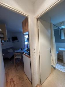una cucina con porta aperta su una stanza con tavolo di appartement à la Foux d'Allos a La Foux