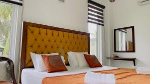 - une chambre avec 2 lits dotés d'oreillers orange et blancs dans l'établissement Villa with a private pool and Garden-Ivory Villa Not for Local, à Kandana