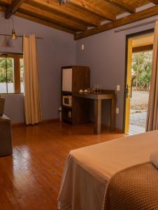 a room with a bed and a table and a television at Pousada Índios Coroados in Praia Grande