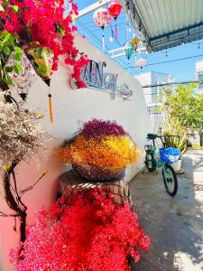 un bouquet de fleurs sur un mur avec un panier dans l'établissement A.N Homestay, à Phan Thiết