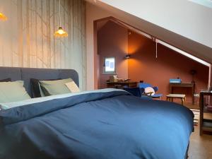 1 dormitorio con 1 cama azul en una habitación en Het Veerhuis, en Oeffelt