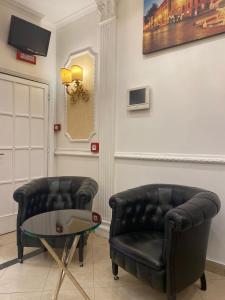 ローマにあるホテル アーダレリの革張りの椅子2脚、ガラステーブル1台(1室あたり)