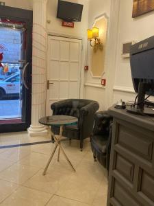 una sala de espera con 2 sillas y una mesa en Hotel Erdarelli, en Roma