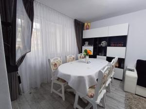 uma sala de jantar branca com uma mesa e cadeiras brancas em sweethomegalati em Galaţi