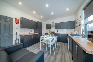 a kitchen with a table and a kitchen with black cabinets at *RC12s* For your most relaxed & Cosy stay + Free Parking + Free Fast WiFi * in Headingley