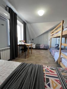 a room with two beds and a table and a bunk bed at Гостевой Отель-125 in Aktau