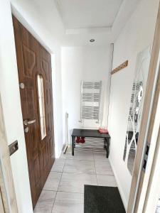 a hallway with a wooden door and a black bench at Modern Urban Haven: Stylish Getaway in Knockmore