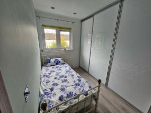 a small bedroom with a bed and a window at Modern Urban Haven: Stylish Getaway in Knockmore