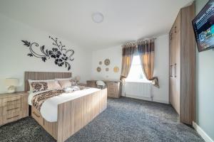 - une chambre avec un grand lit et une télévision dans l'établissement *RC12s* For your most relaxed & Cosy stay + Free Parking + Free Fast WiFi *, à Headingley