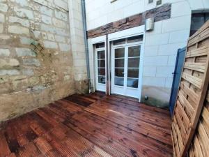 ein leeres Zimmer mit einer Tür und einem Holzboden in der Unterkunft Appart chaleureux avec terrasse in Saumur