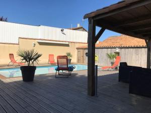 eine Terrasse mit einem Stuhl und einem Pool in der Unterkunft La Roselière - Villa proche mer * Au calme in Fouras