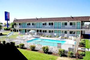 a large building with a swimming pool in front of it at Motel 6-Moses Lake, WA in Moses Lake
