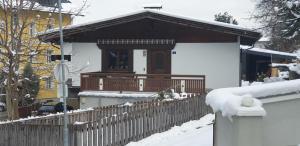 a house with a wooden fence in the snow at Ferienwohnung Singer in Völs