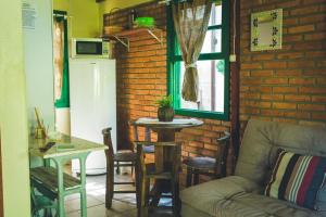 a living room with a couch and a table and a refrigerator at Embausurf - Moradas de Aluguel in Guarda do Embaú