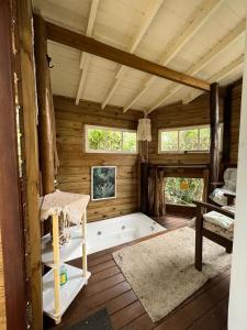 a room with a bath tub in a cabin at Embausurf - Moradas de Aluguel in Guarda do Embaú