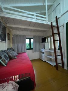 a bedroom with a bunk bed and a ladder at Embausurf - Moradas de Aluguel in Guarda do Embaú