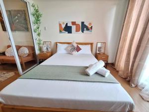 - une chambre avec un grand lit blanc dans l'établissement Cozy 1BR with City and Nature View in Azure, à Manille