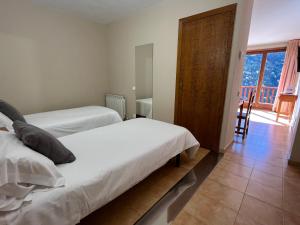 a bedroom with two beds and a door to a balcony at Wuau! Apartamentos Solana de Ransol in Ransol