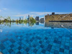 a large pool of water with a city in the background at VAUX Park Street - A collection of 8 luxury lofts in Colombo