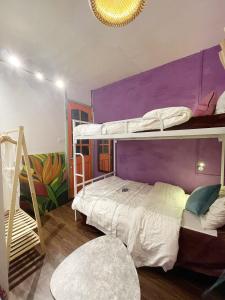 a bedroom with two bunk beds with a purple wall at Lyna House in Hanoi