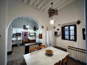 a kitchen and dining room with a table and a refrigerator at Cortijo Buena Vista in Laroles