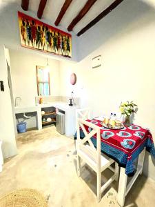 a kitchen with a table with a red table cloth at Butterfly Apartment Zanzibar in Bwejuu