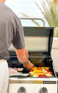 a man is cooking food on a grill at Breathtaking Apartment in Torrevieja