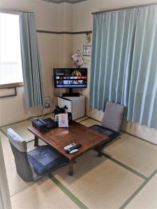 a living room with a wooden table and chairs at OYO Ryokan Hamanako no Yado Kosai - Vacation STAY 48856v in Kosai